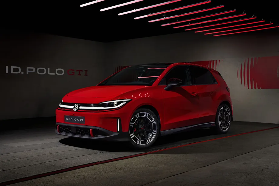 빨간 ID. Polo GTI 가 어두운 실내 세트에 앞 왼쪽 3/4 각도로 서 있다. 뒤쪽 벽에 ID. POLO GTI 라는 큰 글자가 붙어 있고 천장에는 빨간 막대 조명이 비스듬히 걸려 있다. 앞 범퍼의 번호판 자리에도 ID. POLO GTI 가 적혀 있다