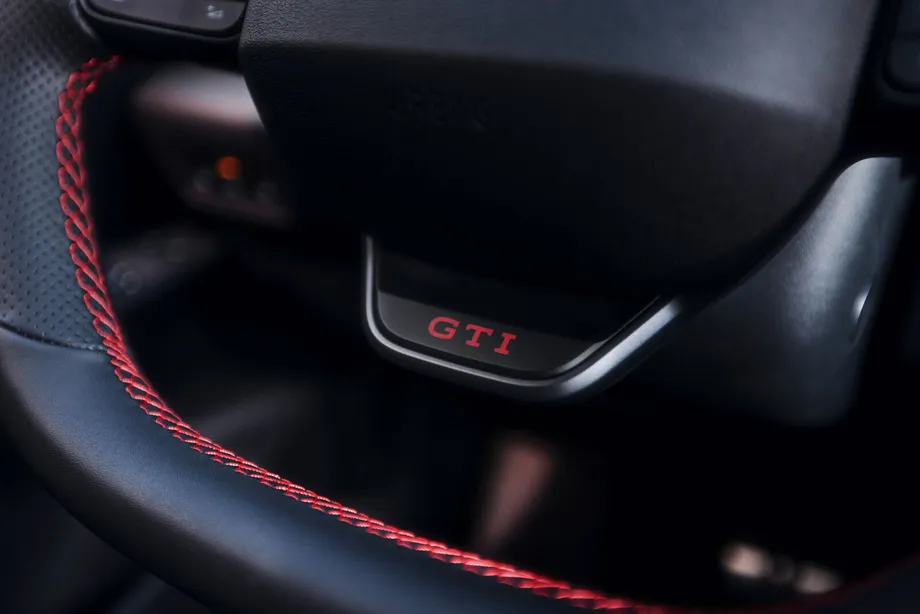 폭스바겐 ID.3 GTI 스티어링 휠 6시 방향에 자리한 빨간 GTI 글자의 버튼 근접 사진. 스티어링 휠 림에 빨간 스티치가 들어가 있다