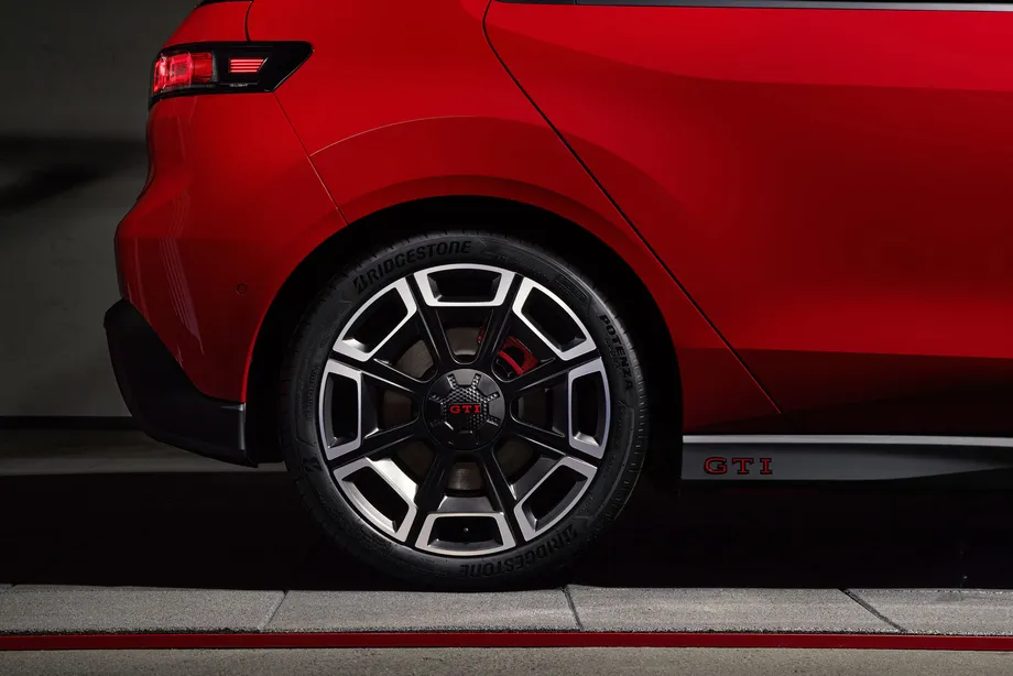 ID. Polo GTI 뒷바퀴 근접 사진. 검은색과 가공 금속면이 섞인 19인치 휠 가운데에 빨간 GTI 글자가 들어간 휠 캡이 있고 안쪽으로 빨간 브레이크 캘리퍼가 보인다. 그 위 사이드 실에는 빨간 GTI 글자가 붙어 있다