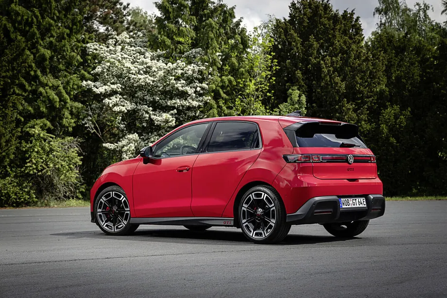 빨간 ID. Polo GTI 를 뒤 왼쪽 3/4 각도에서 본 모습. 좌우 테일램프를 잇는 띠 가운데에 폭스바겐 엠블럼이 있고 그 아래 테일게이트에 빨간 GTI 글자가 붙어 있다. 지붕 끝에는 루프 스포일러가 달려 있고 뒤로 나무가 늘어서 있다